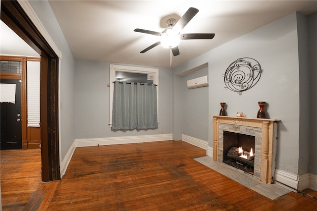 unfurnished living room with a high end fireplace, hardwood / wood-style flooring, a wall mounted AC, and ceiling fan