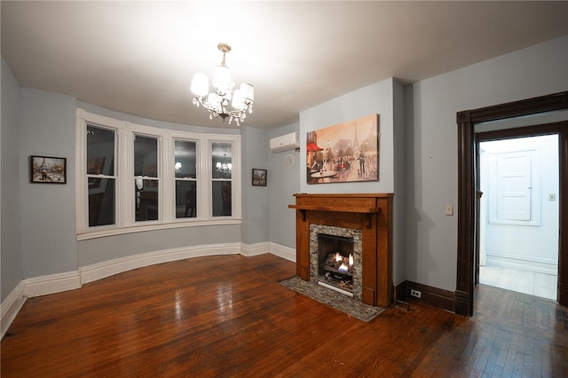 unfurnished living room featuring an AC wall unit, a premium fireplace, dark hardwood / wood-style floors, and an inviting chandelier