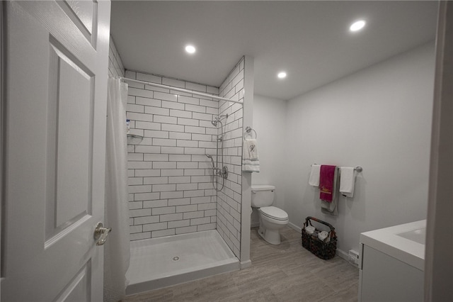 bathroom featuring toilet, vanity, wood-type flooring, and walk in shower