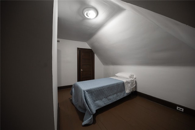 bedroom with dark hardwood / wood-style flooring and lofted ceiling