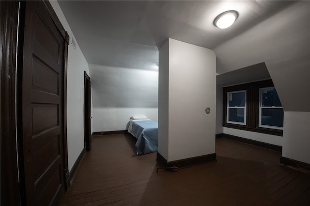 unfurnished bedroom with dark hardwood / wood-style floors and vaulted ceiling