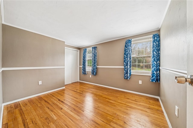 unfurnished room with hardwood / wood-style flooring and crown molding