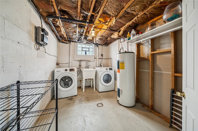 clothes washing area featuring washer and dryer, electric water heater, and sink