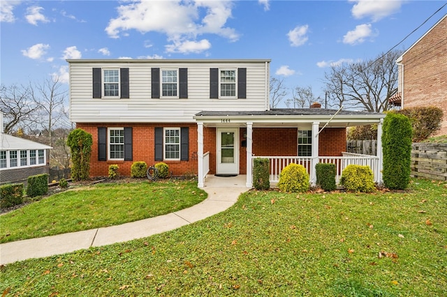 view of property featuring a porch and a front lawn