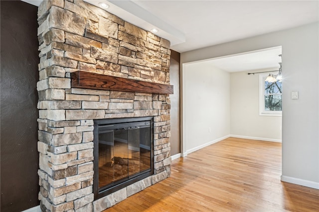 unfurnished living room featuring a stone fireplace and light hardwood / wood-style flooring