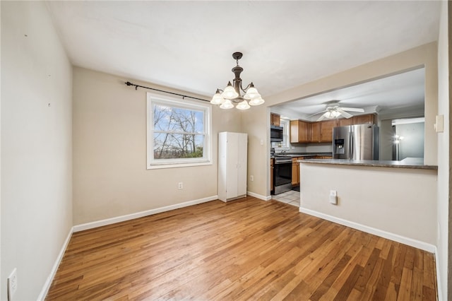 kitchen featuring kitchen peninsula, light hardwood / wood-style flooring, ceiling fan with notable chandelier, and appliances with stainless steel finishes