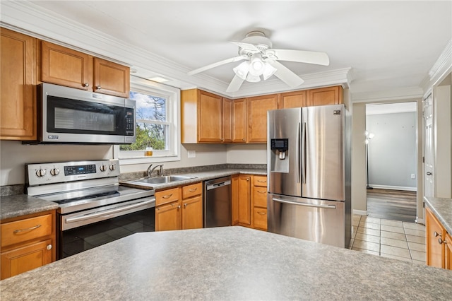 kitchen with ceiling fan, sink, stainless steel appliances, ornamental molding, and light wood-type flooring