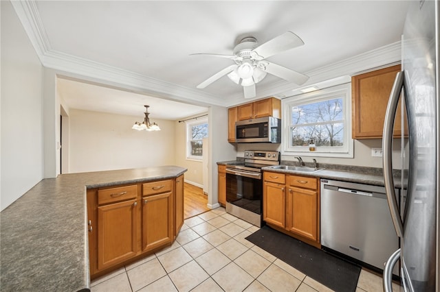 kitchen with plenty of natural light, sink, stainless steel appliances, and hanging light fixtures