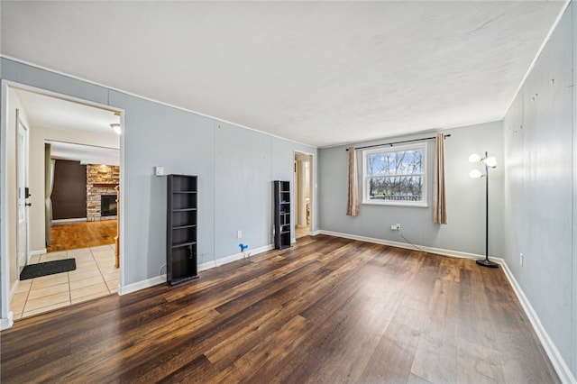 spare room featuring a fireplace and dark hardwood / wood-style flooring