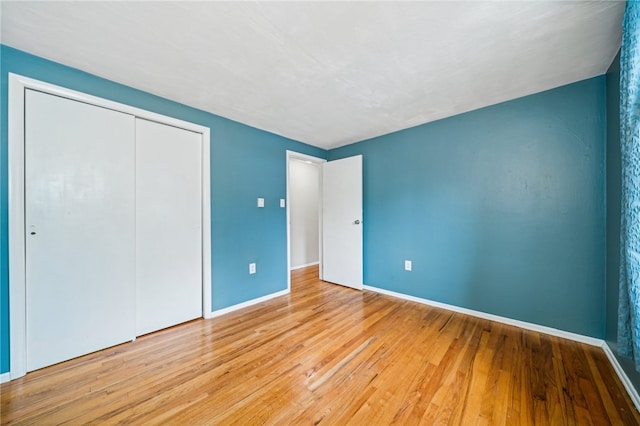 unfurnished bedroom featuring a closet and light wood-type flooring