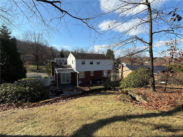 rear view of house featuring a patio and a lawn