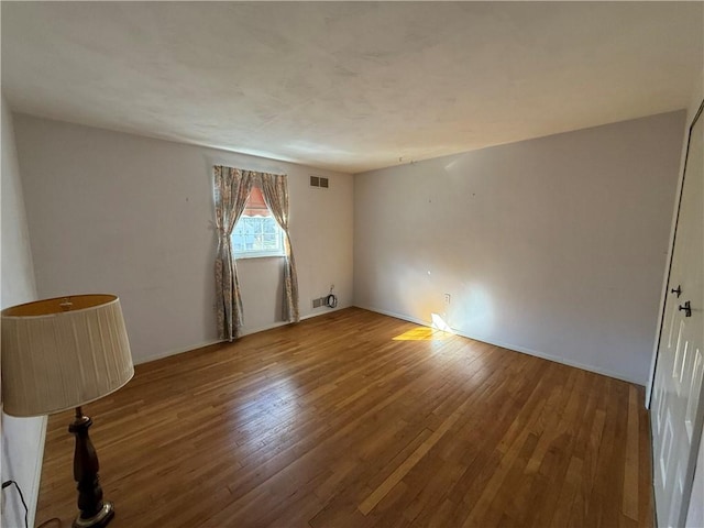 spare room featuring wood-type flooring