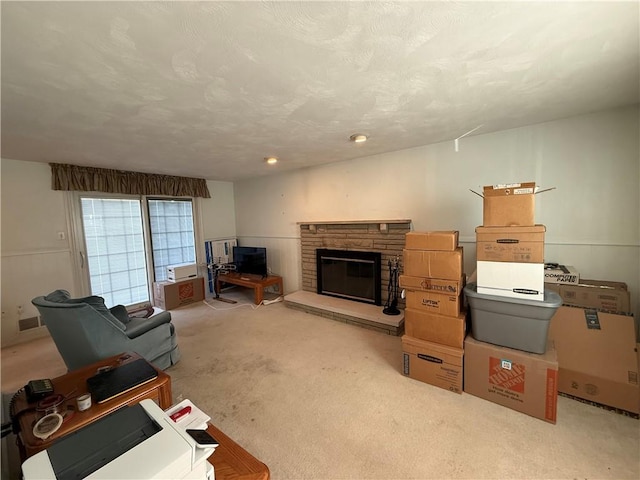 carpeted living room featuring a fireplace and a textured ceiling