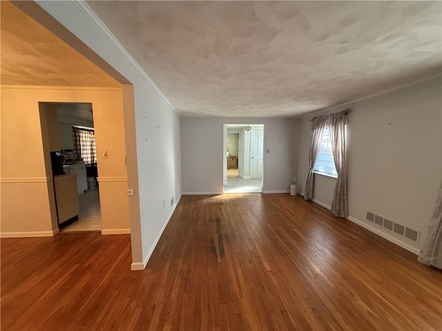 spare room featuring hardwood / wood-style flooring and crown molding