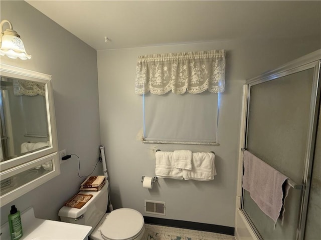 full bathroom featuring toilet, vanity, and bath / shower combo with glass door