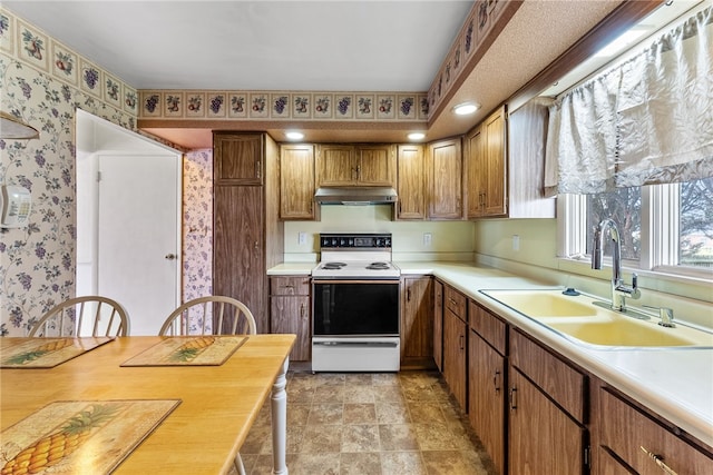 627 Wayne Ave, Monaca, PA 15061 - kitchen with white electric stove, a sink, wallpapered walls, ventilation hood, and light countertops