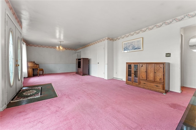 unfurnished living room featuring carpet floors and an inviting chandelier