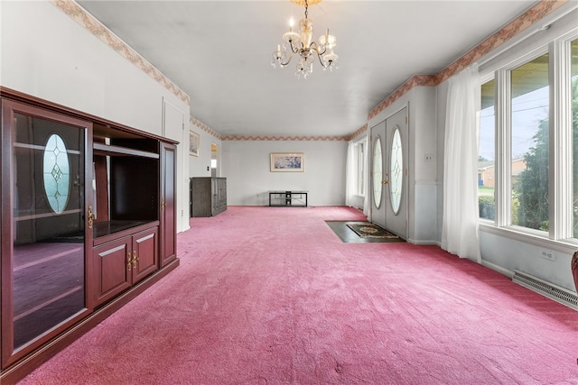 unfurnished living room featuring carpet flooring and a chandelier