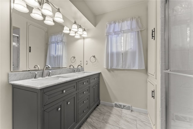 627 Wayne Ave, Monaca, PA 15061 - full bath with double vanity, a chandelier, marble look tiles, baseboards, and a shower with shower door