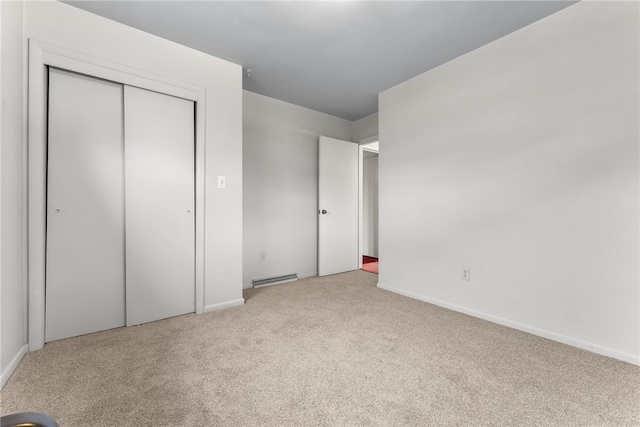 unfurnished bedroom featuring light colored carpet and a closet