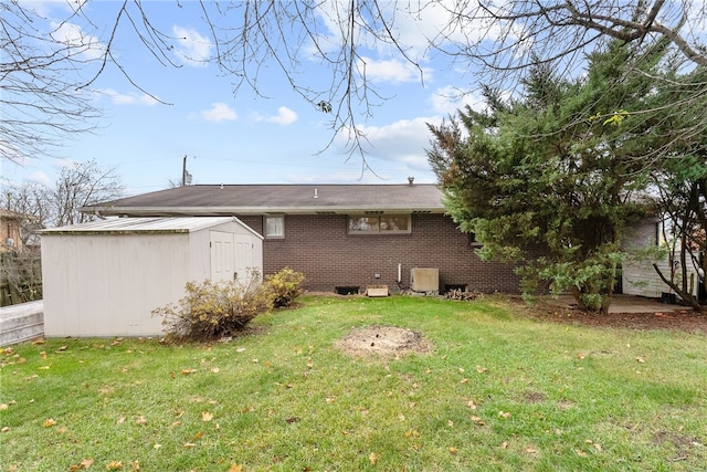 rear view of house featuring a yard and a shed