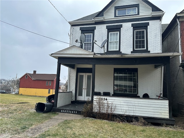 view of front of house featuring covered porch and a front yard