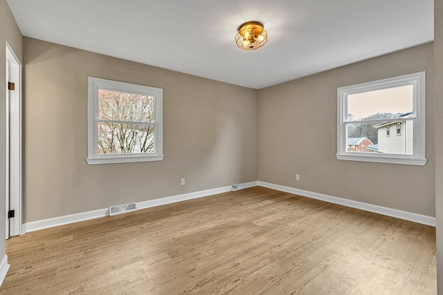 unfurnished room featuring plenty of natural light and light wood-type flooring