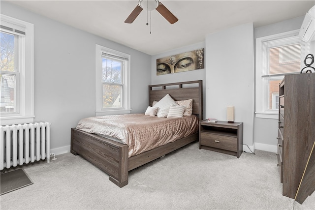 carpeted bedroom with ceiling fan and radiator