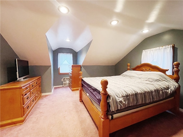 bedroom with light colored carpet and lofted ceiling