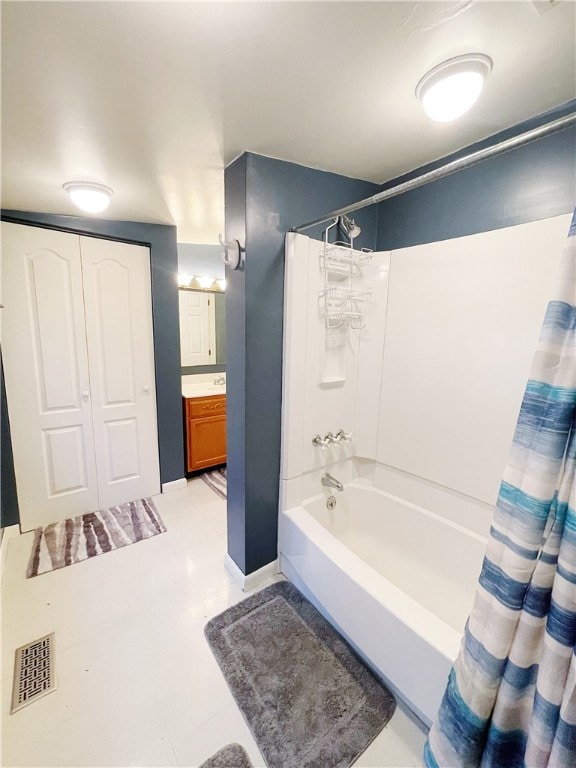 bathroom featuring tile patterned flooring, shower / bath combo, and vanity