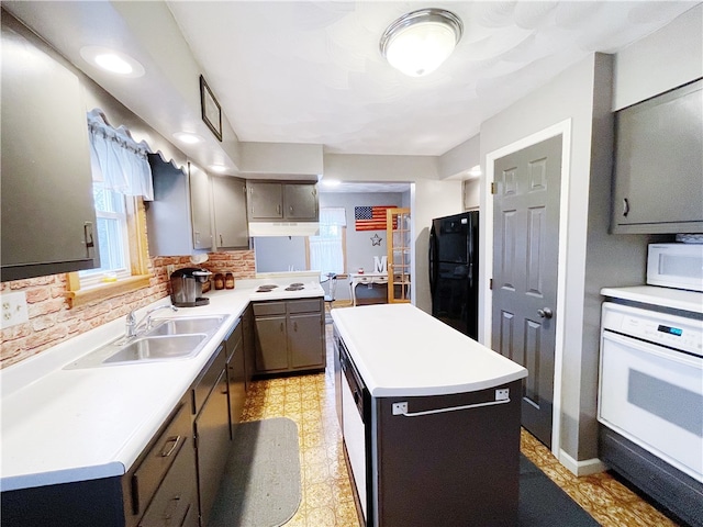 kitchen with tasteful backsplash, sink, a kitchen island, and white appliances