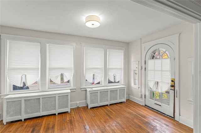 foyer with radiator and hardwood / wood-style floors