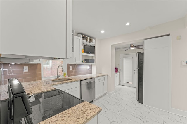 kitchen featuring sink, white cabinetry, light stone counters, appliances with stainless steel finishes, and decorative backsplash