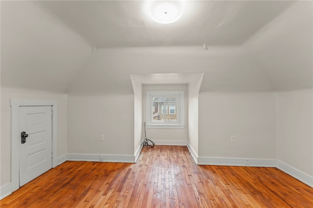 additional living space with lofted ceiling and light hardwood / wood-style flooring