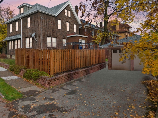 property exterior at dusk featuring a garage