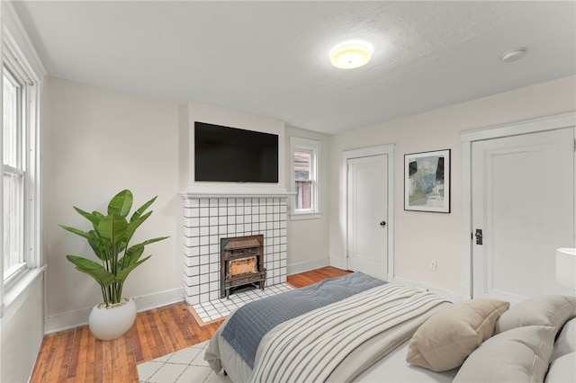 bedroom featuring a textured ceiling, multiple windows, and light wood-type flooring