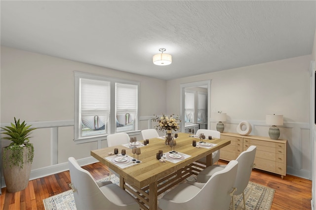 dining room with hardwood / wood-style flooring and a textured ceiling