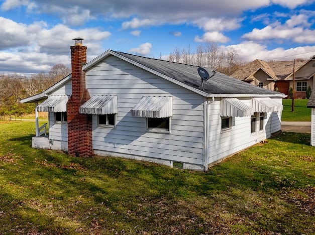 view of side of home with a lawn