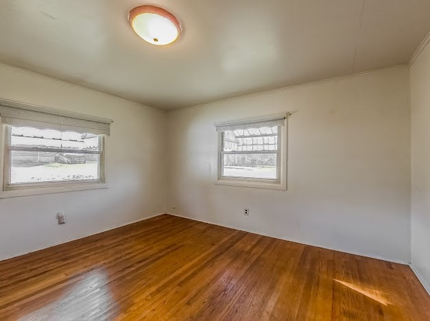 unfurnished room featuring hardwood / wood-style flooring and ornamental molding