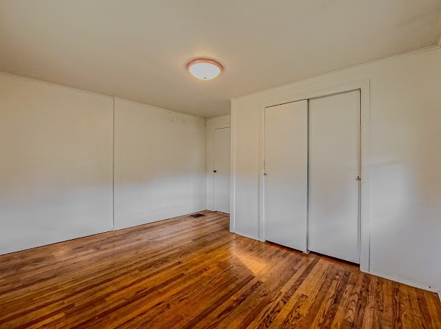 unfurnished bedroom with hardwood / wood-style flooring and a closet