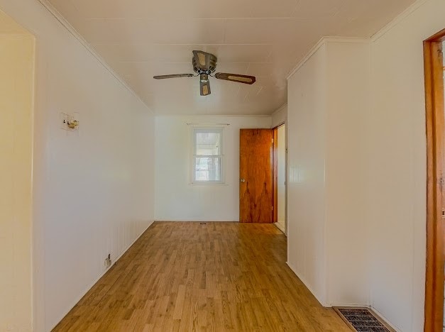 unfurnished room featuring ceiling fan, light hardwood / wood-style floors, and ornamental molding