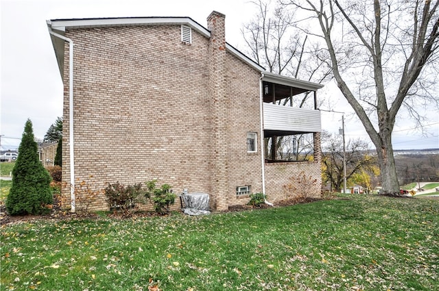 view of side of property with a yard and a balcony