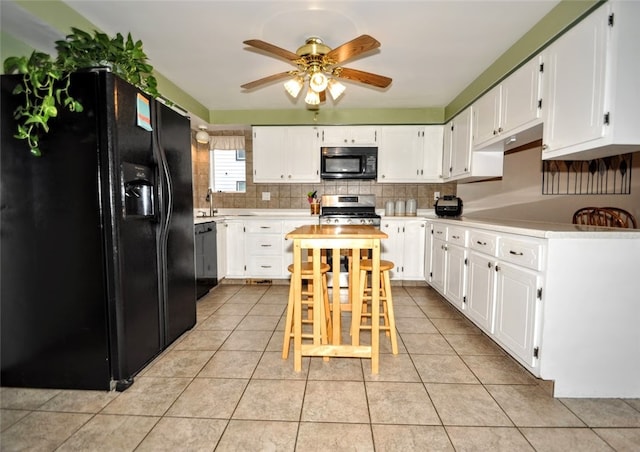 kitchen featuring ceiling fan, light tile patterned floors, backsplash, white cabinets, and black appliances