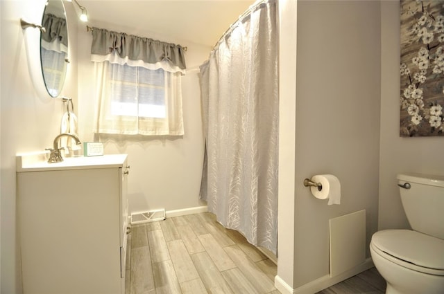 bathroom featuring hardwood / wood-style floors, vanity, and toilet