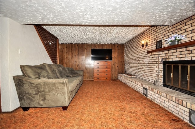 carpeted living room with wood walls, a fireplace, and a textured ceiling