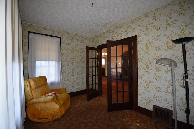 sitting room featuring a textured ceiling and french doors