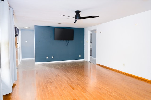 unfurnished living room with ceiling fan and wood-type flooring