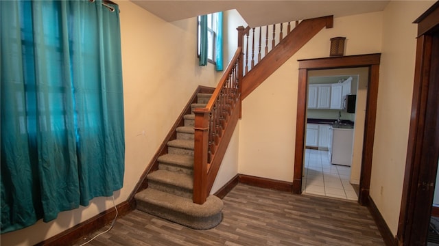 stairway with hardwood / wood-style floors and sink