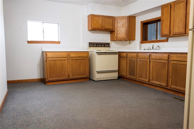 kitchen with white range oven and dark colored carpet