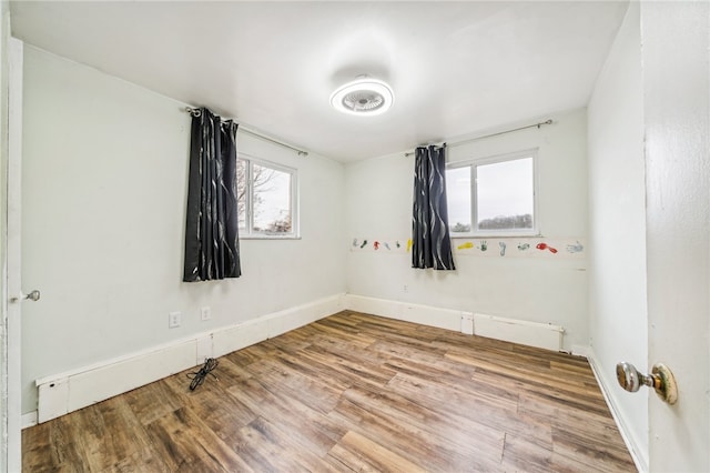 unfurnished room featuring plenty of natural light and hardwood / wood-style floors